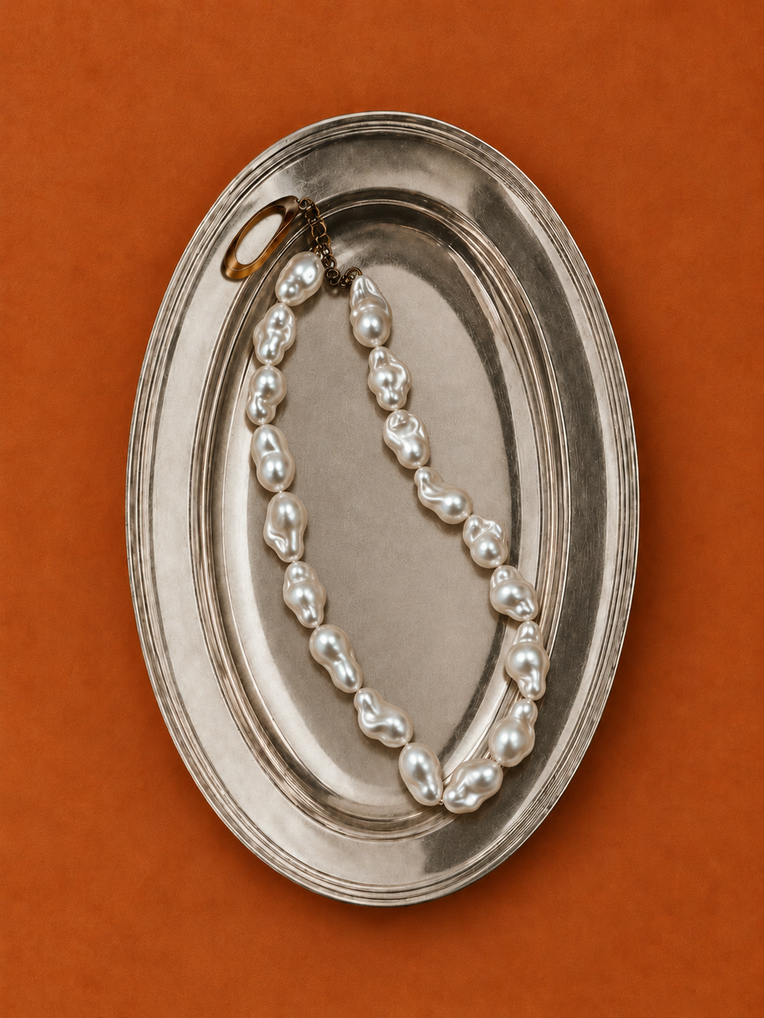 Baroque pearl necklace on an antique silver tray