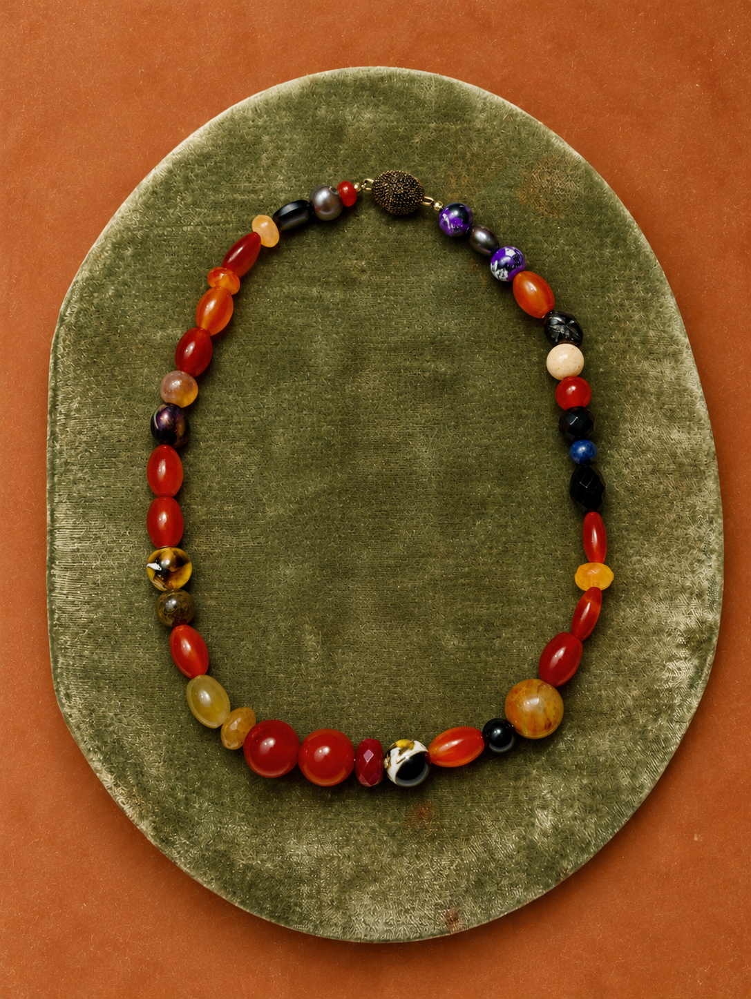 Multi-stone necklace on a green velvet tray