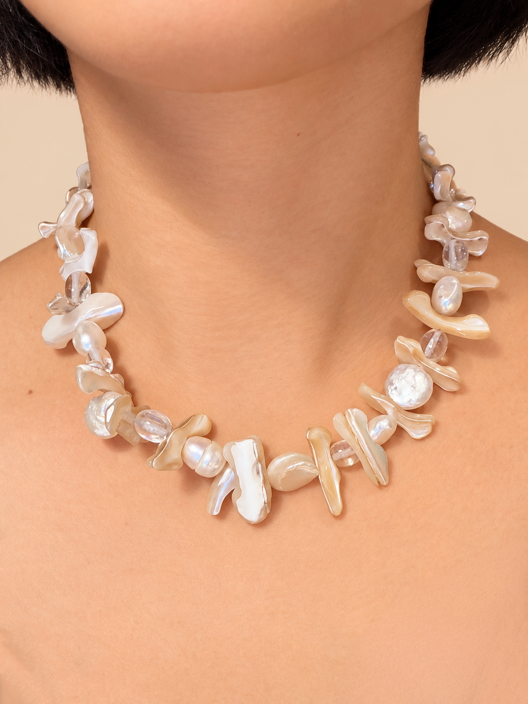 Pearl and shell necklace worn close to the neck