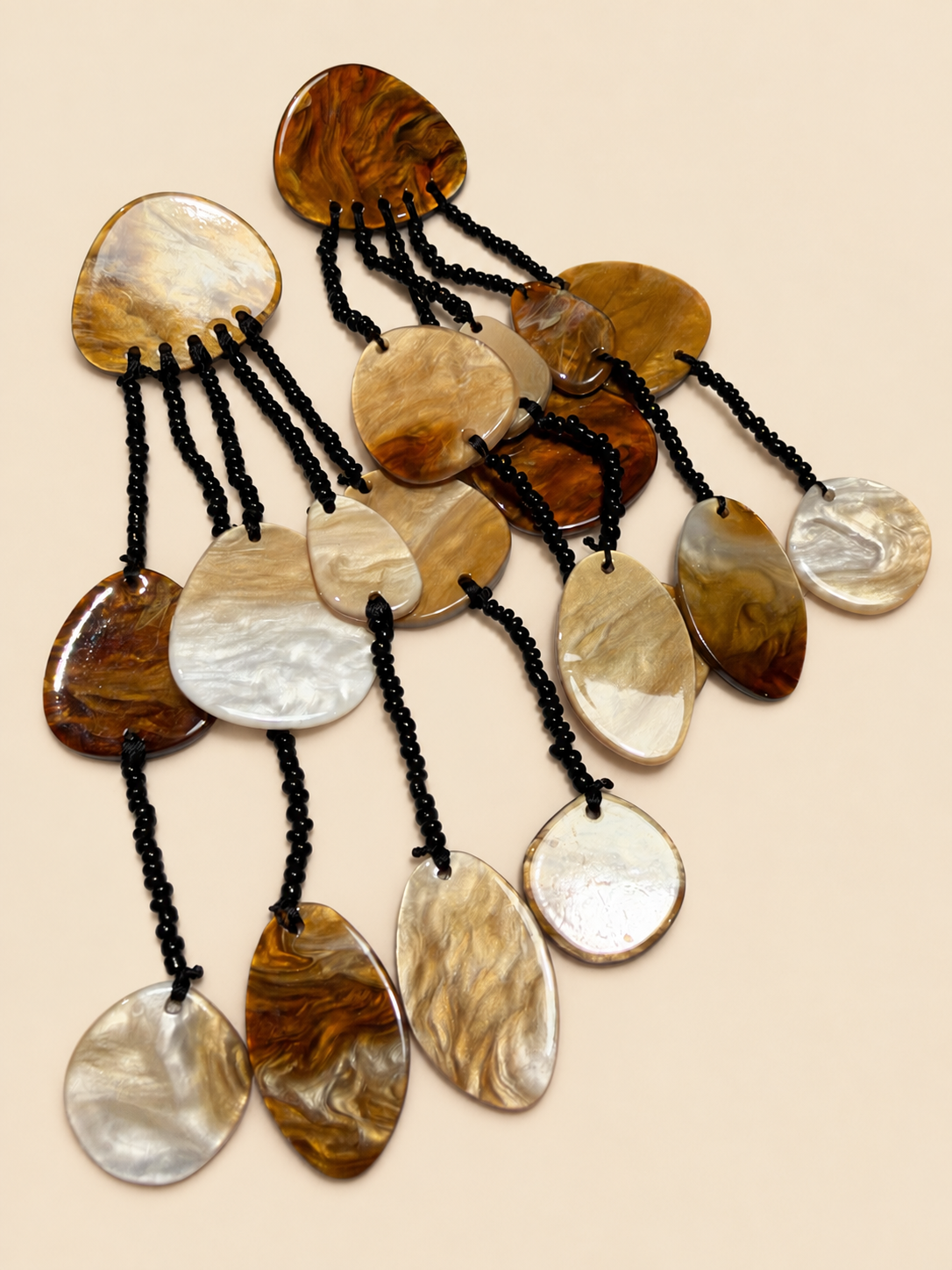 Shell drop earrings laid flat, showing the acetate and mother-of-pearl discs